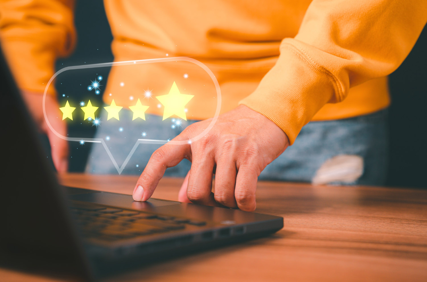 Hand hovering over a laptop showing a 5-star rating